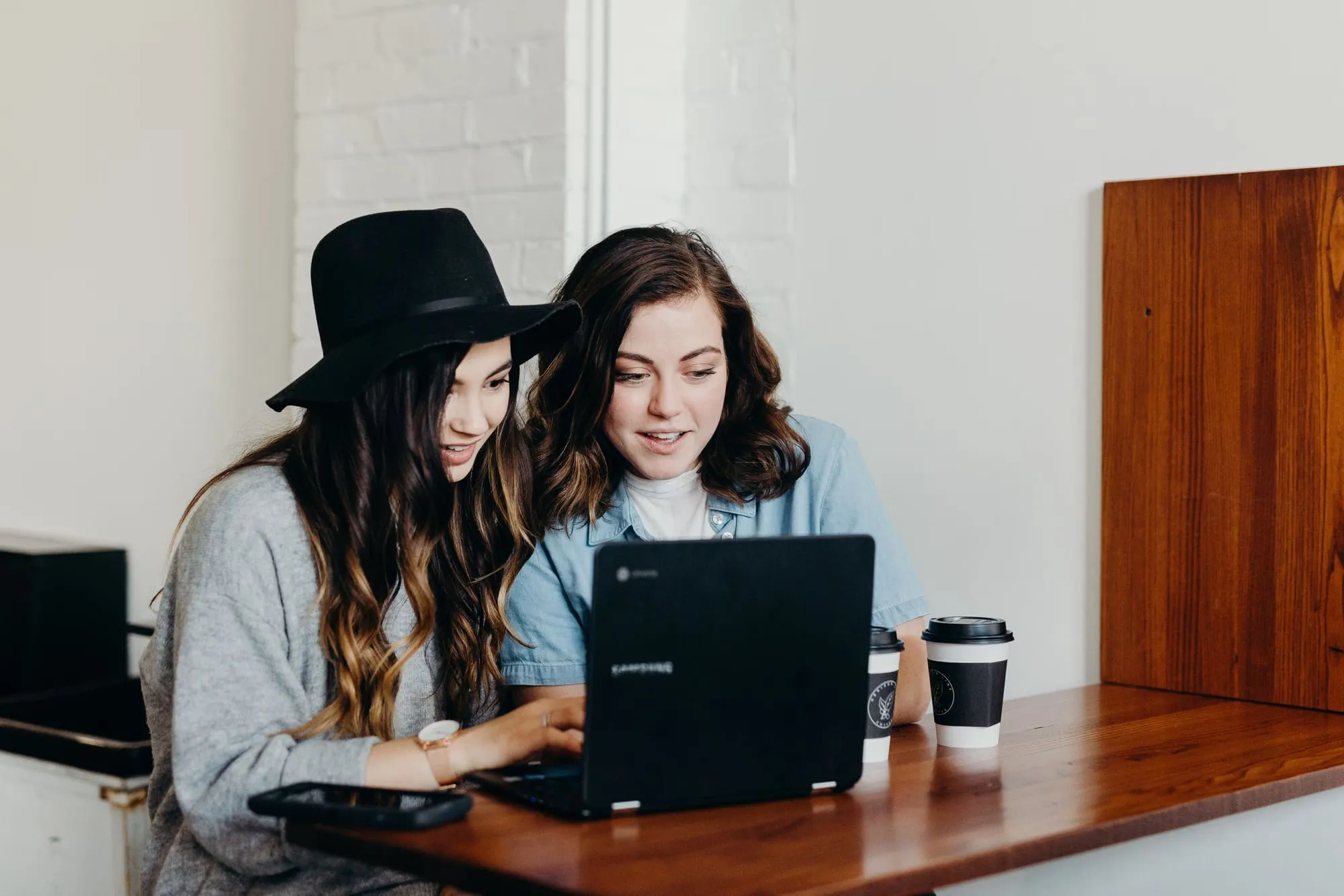 Twee makers bekijken samen een project op een laptop